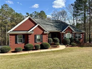 Charming red brick home with manicured lawn and mature trees offering great curb appeal at 401 Carrie Kathleen Ter, Carrollton, GA 30116