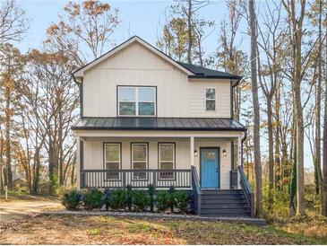 Charming two-story home featuring a welcoming front porch, neutral siding, and a pop of color with its bright blue front door at 741 Se Knox Se Dr, Atlanta, GA 30315