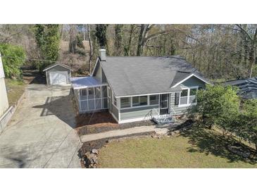 Charming home with a screened-in porch, lush lawn, gray siding, and a detached garage at 19 Grove Park Nw Pl, Atlanta, GA 30318
