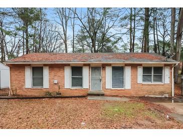 Charming single-story brick home featuring white shutters and mature trees in a quiet neighborhood setting at 491 Bolton Nw Rd, Atlanta, GA 30331