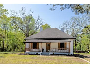 Charming single-story home featuring a covered front porch with wooden pillars and shutters, set in a lush green lawn at 6592 Factory Shoals Sw Rd, Mableton, GA 30126