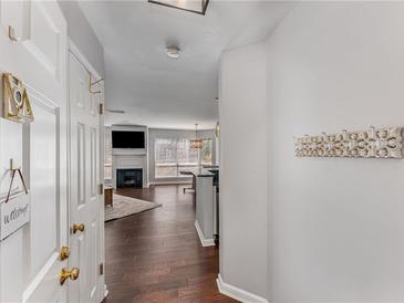 Welcoming entryway with hardwood floors leads into a cozy living area featuring a fireplace and abundant natural light at 244 13Th Ne St # 302, Atlanta, GA 30309