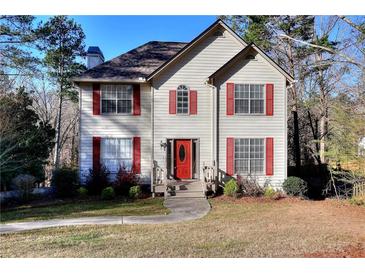 Charming two-story home with red shutters, complemented by a well-maintained lawn and mature trees at 4751 Lorient Ct, Snellville, GA 30039