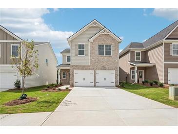 Charming two-story home featuring a brick and siding exterior, attached two-car garage, and well-manicured lawn at 2016 Wyndham Pl, Conyers, GA 30013