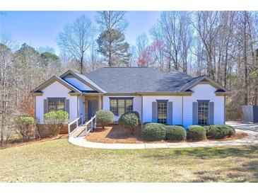 Charming single-story home with a well-maintained lawn and mature trees in a serene setting at 1620 Rising Mist Ln, Cumming, GA 30041