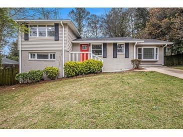 Charming brick home featuring a split-level design and inviting red front door at 3409 Glensford Dr, Decatur, GA 30032