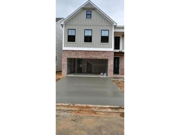 New construction home with board and batten siding, brick accents, and a concrete driveway leading to a two-car garage at 1067 Crest Mill Dr, Marietta, GA 30008