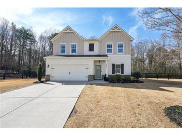 Charming two-story home featuring board and batten siding, a two-car garage, and manicured landscaping at 4825 Marco Ln, Cumming, GA 30028