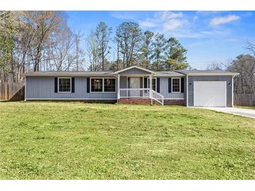 Charming one-story home with a well-maintained lawn and attached garage, perfect for suburban living at 1833 Lost Mountain Rd, Powder Springs, GA 30127