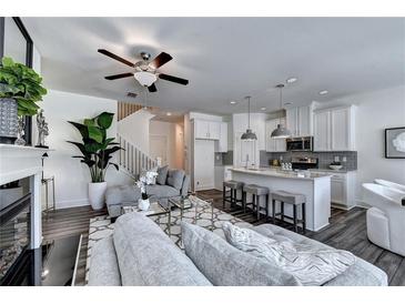 Open concept living room featuring an island kitchen, modern furniture, and plenty of natural light at 2698 Ne Almand Ln, Conyers, GA 30013