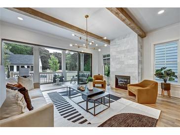 Bright living room boasts hardwood floors, modern light fixture, marble fireplace, and deck access at 2171 James Aly, Atlanta, GA 30345