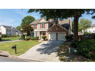 Charming two-story home with brick accents, red shutters, manicured lawn, and a paved double car driveway at 900 Cherringham Ct, Alpharetta, GA 30005