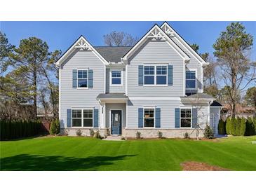 Charming two-story home with gray siding, blue shutters and manicured lawn at 3725 Heron Creek Ct, Loganville, GA 30052