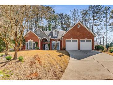 Beautiful brick home with well-manicured lawn and a two-car garage provides great curb appeal at 500 Huntgate Rd, Woodstock, GA 30189