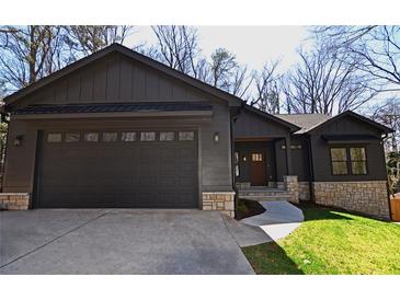 Beautiful one-story home with a two-car garage, stone accents, and a manicured lawn at 2078 Lyle Ave, College Park, GA 30337