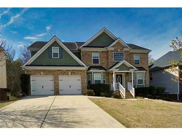 Charming two-story brick home with a two-car garage and well-manicured front lawn at 4001 Oak Field Dr, Loganville, GA 30052