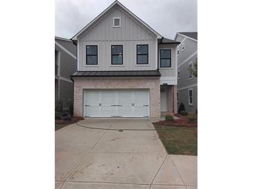 Charming two-story home with a brick-and-wood exterior and a white garage door at 1071 Crest Mill Dr, Marietta, GA 30008