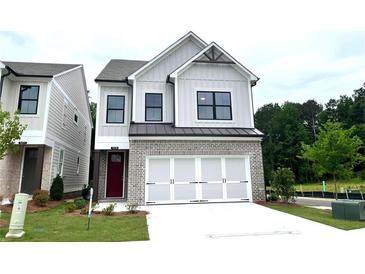 Charming two-story home featuring a brick facade, white siding, and a two-car garage on a manicured lawn at 1075 Crest Mill Dr, Marietta, GA 30008