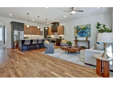 Open-concept living room featuring hardwood floors, modern lighting, kitchen island and stylish contemporary furniture at 2159 James Aly, Atlanta, GA 30345
