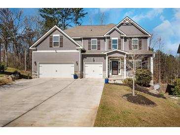 Charming two-story home with gray siding, three-car garage, and well-manicured lawn in a suburban setting at 541 Glen Abbey Se Cir, Mableton, GA 30126