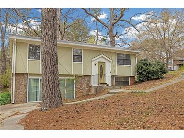 Split-level home with unique architectural details and a stone facade on the lower level at 4690 Big Valley Ct, Stone Mountain, GA 30083