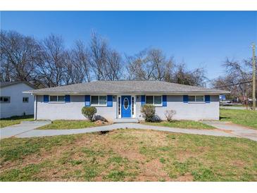 Charming single-story home with blue shutters, a blue door, and mature trees at 1393 Vesta Ave, Atlanta, GA 30344