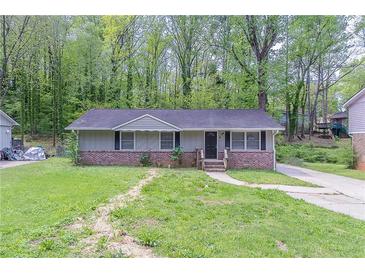 Charming single-story home with a brick foundation, inviting front yard, and driveway at 4089 Lindsey Dr, Decatur, GA 30035