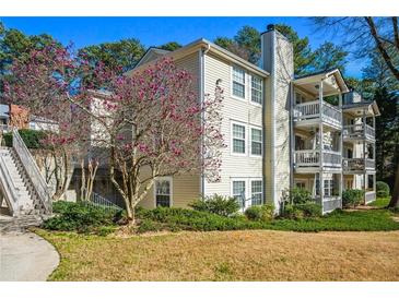 Three-story condo building with multiple balconies and charming landscaping at 1401 Keys Crossing Ne Dr, Atlanta, GA 30319