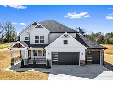 Newly constructed two-story home with a stylish facade, black framed windows and a two car garage at 4285 Haynes Cir, Snellville, GA 30039