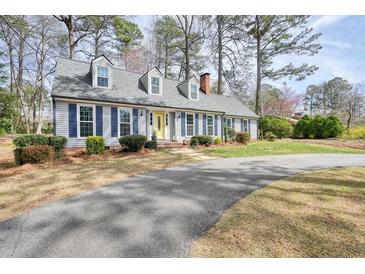 Charming single Gathering home featuring a yellow front door, blue shutters, and well maintained lawn at 1495 Longwood Sw Dr, Marietta, GA 30008