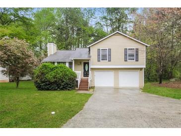 Split-level home with a large driveway and manicured lawn, offering curb appeal and convenience at 2895 Wildflower Ln, Snellville, GA 30039