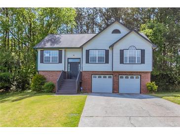 Charming two-story home features a two-car garage, landscaped front yard, and inviting entryway at 1202 W Briar Gate Ct, Riverdale, GA 30296