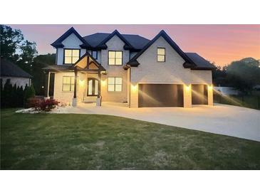 Striking two-story home showcases a brick facade, three-car garage, and professionally landscaped yard at 1952 Azalea Dr, Lawrenceville, GA 30043
