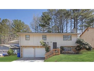 Split-level home with two-car garage, manicured lawn and wood/stone accents at 2044 Teal Cv, Lithonia, GA 30058