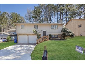 Charming split-level home featuring a two-car garage and well-maintained front yard at 2044 Teal Cv, Lithonia, GA 30058