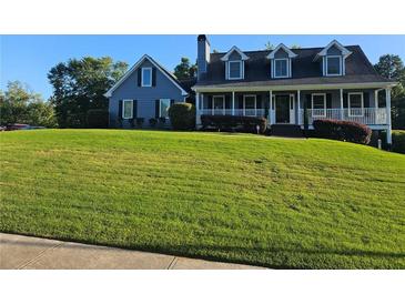 Charming two-story home with a manicured lawn and a welcoming front porch at 2467 Sky Valley Dr, Dacula, GA 30019