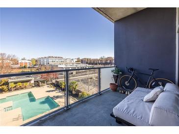 Relaxing condo balcony features a daybed, bike and view of community pool at 130 Arizona Ne Ave # 302, Atlanta, GA 30307