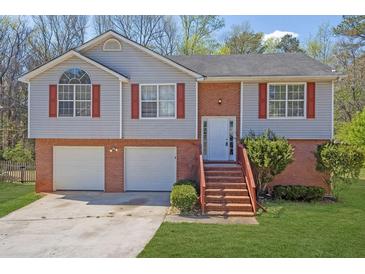 Charming home featuring a two-car garage, brick accents, and a welcoming front entrance with stairs at 3021 Hampton Club Way, Lithonia, GA 30038