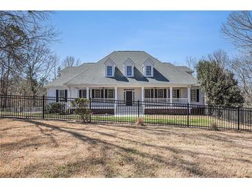 Charming single-Gathering home featuring a welcoming front porch and black wrought iron fence at 7985 Thunder River Way, Cumming, GA 30028