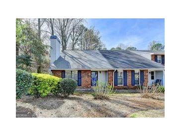 Charming home featuring a brick facade, mature landscaping and a prominent chimney at 1335 Jamestowne Trl, Alpharetta, GA 30009