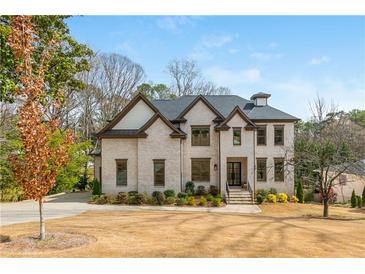 Stunning two-story brick home with manicured lawn and lush landscaping providing beautiful curb appeal at 5915 Brookgreen Rd, Atlanta, GA 30328