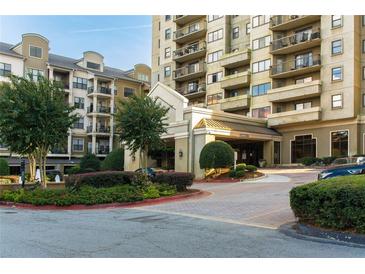 Elegant condo building entrance featuring well-maintained landscaping and a covered drive-through at 795 Hammond Dr # 407, Sandy Springs, GA 30328