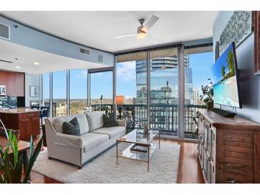Bright living room features large windows with amazing city views and comfortable seating arrangement at 3324 Peachtree Ne Rd # 2807, Atlanta, GA 30326