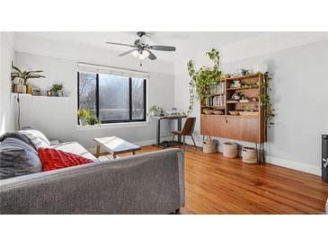 Bright living room with hardwood floors, a ceiling fan, and a cozy gray sofa with large window at 708 Argonne Ne Ave # 5, Atlanta, GA 30308
