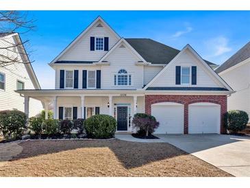 Charming two-story home with a brick accent, front porch and manicured landscaping at 1236 Nottoway Trl, Marietta, GA 30066