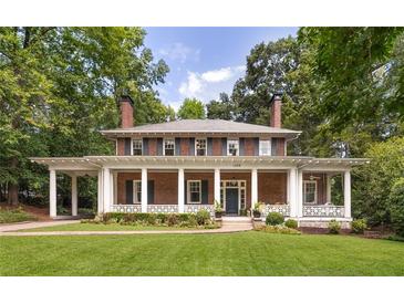 Charming two-story brick home with a full front porch, decorative columns and a lush green lawn at 1308 Fairview Ne Rd, Atlanta, GA 30306