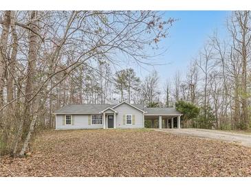 Charming single-story home featuring a carport and a well-maintained front lawn surrounded by mature trees at 5001 Oakdale Dr, Douglasville, GA 30135