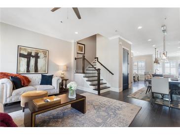 Inviting living room featuring dark wood floors, staircase, stylish seating, and eye-catching modern art at 345 Glen Iris Ne Dr # 5, Atlanta, GA 30312