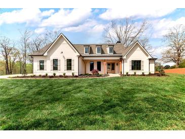 Charming white brick home featuring a manicured lawn and welcoming front porch at 6110 Harvest Way, Cumming, GA 30028