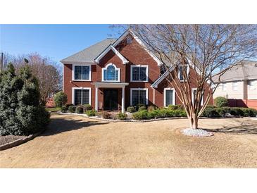 Two-story home with manicured lawn and landscape, complete with covered entry and ample natural light at 5289 Browning Sw Way, Lilburn, GA 30047